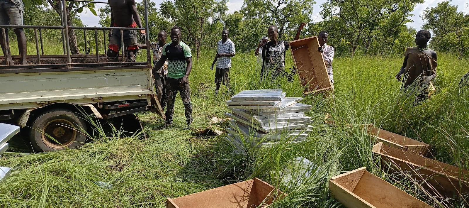 Beekeeper tending to hive in green field